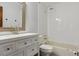 A bright bathroom includes a tiled shower/tub and a vanity with a framed mirror at 5370 S Flanders Way, Centennial, CO 80015