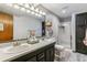 Bathroom with a double vanity, shower and black cabinets with shelves at 5370 S Flanders Way, Centennial, CO 80015