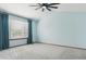 An empty carpeted bedroom features a ceiling fan and window with blue drapes at 5370 S Flanders Way, Centennial, CO 80015