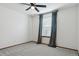 An empty carpeted bedroom features a ceiling fan and window with grey drapes at 5370 S Flanders Way, Centennial, CO 80015