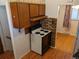 Functional kitchen with laminate floors, wood cabinets, and a white electric range at 5370 W Arizona Pl, Lakewood, CO 80232