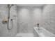 Serene bathroom with soaking tub, shower, light tiling, and sophisticated fixtures for a luxurious experience at 1750 Wewatta St # 1301, Denver, CO 80202
