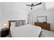 Bright bedroom with a modern wood-framed bed, stylish dresser, and a sleek ceiling fan at 1750 Wewatta St # 1301, Denver, CO 80202