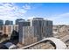 A wide aerial view of high-rise buildings with modern architecture near a transportation station at 1750 Wewatta St # 1301, Denver, CO 80202