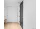 Bright hallway with wood floors, a dark door and a sliding closet door at 1750 Wewatta St # 1301, Denver, CO 80202