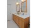 Bright bathroom featuring double wooden vanities, white countertops, and sleek fixtures and finishes at 2500 Locust St, Denver, CO 80207