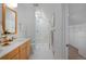 Bathroom featuring frameless glass shower, white tile, and wooden vanity with white countertops at 2500 Locust St, Denver, CO 80207