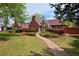 Charming brick home with a well-manicured lawn and a stone pathway leading to the front door at 2500 Locust St, Denver, CO 80207