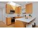 Well-lit kitchen with modern appliances, wooden cabinets, and a white countertop bar at 2500 Locust St, Denver, CO 80207