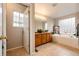 Bright bathroom featuring a soaking tub, window, and a vanity with granite counters at 3802 Lee Cir, Wheat Ridge, CO 80033