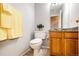 Neutral bathroom featuring granite vanity, toilet and yellow towels that compliment the decor and functionality of the space at 3802 Lee Cir, Wheat Ridge, CO 80033