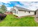 Side exterior view of the home showcasing the beautiful lawn, garden and brick privacy wall at 3802 Lee Cir, Wheat Ridge, CO 80033