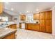 Bright kitchen featuring wooden cabinets, granite countertops, and tile flooring at 3802 Lee Cir, Wheat Ridge, CO 80033