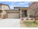 Tan two-story house with stone accents, two-car garage, and landscaping at 3280 Youngheart Way, Castle Rock, CO 80109