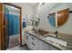Bathroom with double sinks, granite countertop, mirrors, and a shower with blue curtain at 9251 Sand Hill Trl, Highlands Ranch, CO 80126