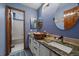 Bathroom with granite countertops, vanity with plenty of storage, mirrors, and shower at 9251 Sand Hill Trl, Highlands Ranch, CO 80126
