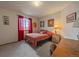 Bedroom with red curtains, a small bed, and a wooden desk and chair at 9251 Sand Hill Trl, Highlands Ranch, CO 80126