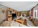 Cozy living room with a fireplace, built-in shelving, neutral carpet and a large window for natural light at 9251 Sand Hill Trl, Highlands Ranch, CO 80126