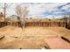 Spacious backyard with wood fence, patio, and wood retaining wall at 441 Elbert Way, Denver, CO 80221