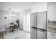 Bright dining space features a round table, modern chairs, a stylish chandelier, and stainless refrigerator at 441 Elbert Way, Denver, CO 80221