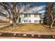 Traditional two-story home exterior with mature trees, a well-kept lawn and a brick-lined garden bed at 441 Elbert Way, Denver, CO 80221