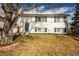 Charming two-story home with green shutters, a well-maintained lawn, and mature shade tree at 441 Elbert Way, Denver, CO 80221