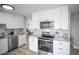 Bright, updated kitchen featuring stainless steel appliances, white cabinets, and modern finishes at 441 Elbert Way, Denver, CO 80221