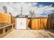 Backyard shed with double doors sits adjacent to wood fence and provides outdoor storage at 441 Elbert Way, Denver, CO 80221