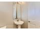 Cozy powder room with a pedestal sink, a framed mirror, and white trim offering a minimalist design at 812 Mulberry St, Louisville, CO 80027