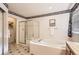 Bathroom with a soaking tub, glass-enclosed shower, and classic design elements at 14045 E Grand Ave, Aurora, CO 80015