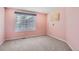 Neutral bedroom features a light pink wall and a sunlit window at 14045 E Grand Ave, Aurora, CO 80015