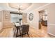 Elegant dining room with hardwood floors, a chandelier, and a view into the adjacent kitchen at 14045 E Grand Ave, Aurora, CO 80015