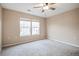 Neutral bedroom features plush carpet, ceiling fan, and two windows for natural light at 1473 Red Cliff Way, Castle Rock, CO 80109