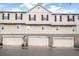 Three-car garage with traditional tan doors and shutters, complemented by well-maintained landscaping at 1473 Red Cliff Way, Castle Rock, CO 80109