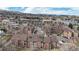 Aerial view of condo complex surrounded by mature trees, nearby mountains, and neighborhood at 12368 W Nevada Pl # 303, Lakewood, CO 80228