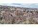 Aerial view of condo complex surrounded by mature trees, nearby mountains, and neighborhood at 12368 W Nevada Pl # 303, Lakewood, CO 80228