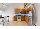 Well-lit kitchen featuring wooden cabinetry, stainless steel appliances, and light wood flooring with adjacent breakfast table at 12368 W Nevada Pl # 303, Lakewood, CO 80228