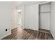 Bedroom featuring wood-look floors, white walls, and closet with sliding doors at 298 S Hoover Ave, Louisville, CO 80027