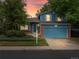 Charming two-story home with a blue exterior, brick accents, and a well-manicured front yard against a colorful sky at 298 S Hoover Ave, Louisville, CO 80027