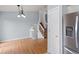 Open kitchen with stainless steel appliances, white cabinets, chandelier, wood floors, and view into adjacent spaces at 298 S Hoover Ave, Louisville, CO 80027