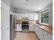Functional kitchen featuring white cabinets, stainless steel appliances, and wood countertops for efficient cooking and storage at 298 S Hoover Ave, Louisville, CO 80027