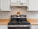 Kitchen featuring a black electric range with wooden countertops and tile backsplash at 298 S Hoover Ave, Louisville, CO 80027