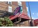 Exterior of Charlie Brown's Bar & Grill featuring vintage signage, a red awning, and a charming old-world design at 1175 N Emerson St # 308, Denver, CO 80218