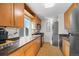 A bright kitchen featuring wood cabinets, granite countertops, and modern appliances at 1175 N Emerson St # 308, Denver, CO 80218