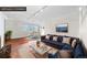 A virtually staged living room featuring a blue couch, dining table, and wood floors at 1175 N Emerson St # 308, Denver, CO 80218