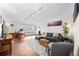 Spacious living room with desk, gray couch, and great natural light from the large window at 1175 N Emerson St # 308, Denver, CO 80218