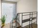 Staircase illuminated by a unique glass block window, complemented by iron railing and green plants at 1175 N Emerson St # 308, Denver, CO 80218