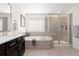 Bathroom featuring a large vanity, soaking tub, and separate glass enclosed shower at 14278 Forest St, Thornton, CO 80602