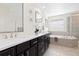 Bathroom features a double vanity, soaking tub, and tile flooring at 14278 Forest St, Thornton, CO 80602
