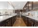 Modern kitchen with white quartz countertops, dark wood cabinets, and stainless steel appliances at 14278 Forest St, Thornton, CO 80602